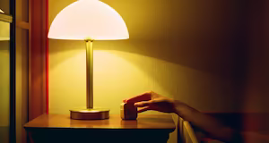A modern half-dome lamp on top of a bedside table