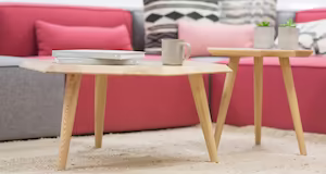 Modern wood coffee tables in front of bright red couches
