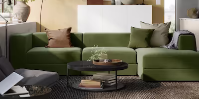 A forest green 4 seat sofa with a matching footrest or extension